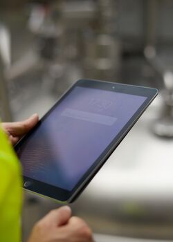 Eine Person die eine Begehung mit dem Tablet durchführt