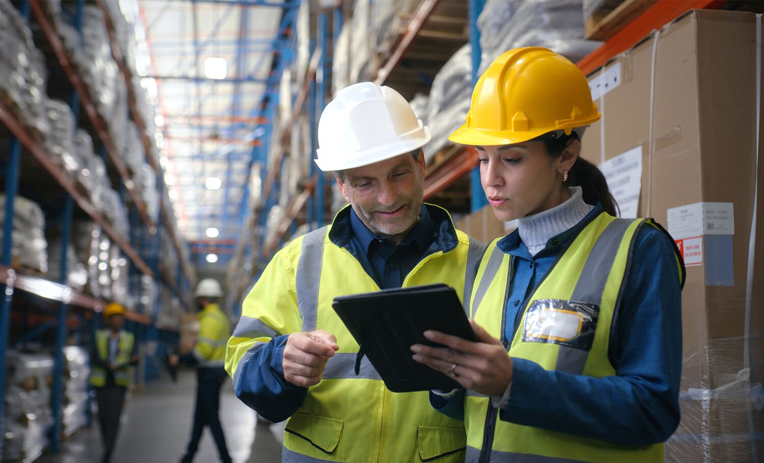 Zwei Personen die im Lager auf ein Tablet schauen und sich im SafetyPlanner umschauen