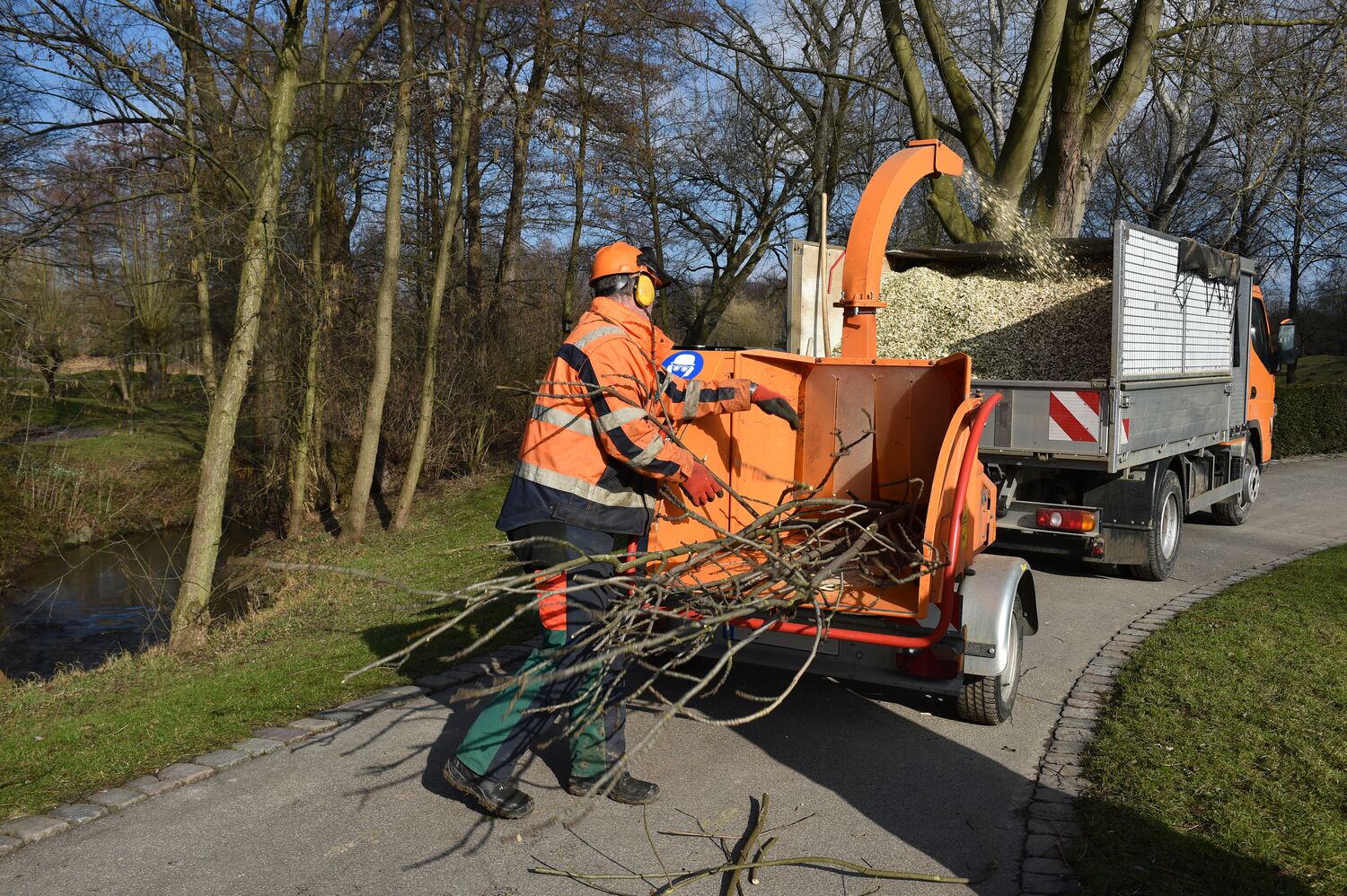 Bauhofmitarbeiter welche Äste in einen Hexer stecken
